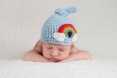Rainbow baby (born from pregnancy after a miscarriage) wearing a blue rainbow hat | Dallas IVF
