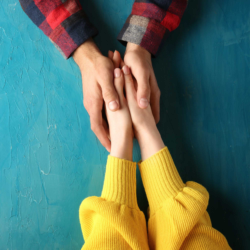 A man and a woman holding hands across a table after undergoing infertility treatment | Dallas IVF | 5 Texas locations