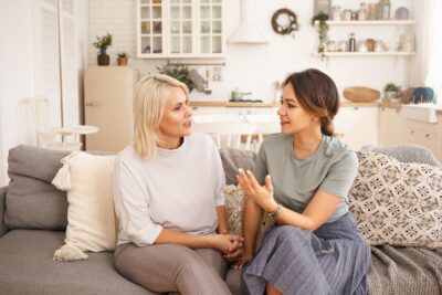 Two women, one younger one older, having a conversation seated on a couch | Dallas IVF treats endometriosis and PCOS | Texas