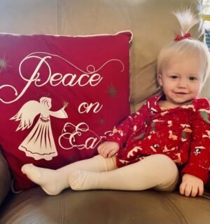 Happy blonde baby Ainsley in red highlights IUI and successful conception after endometriosis treatment | Dallas IVF