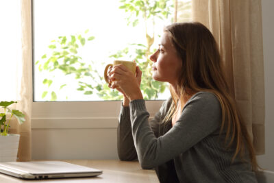 Woman holding coffee cup thinking about symptoms of PCOS | Dallas IVF | Frisco & Dallas, TX